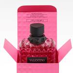 A Valentino perfume bottle displayed in an open pink box, featuring a textured design and a black cap.