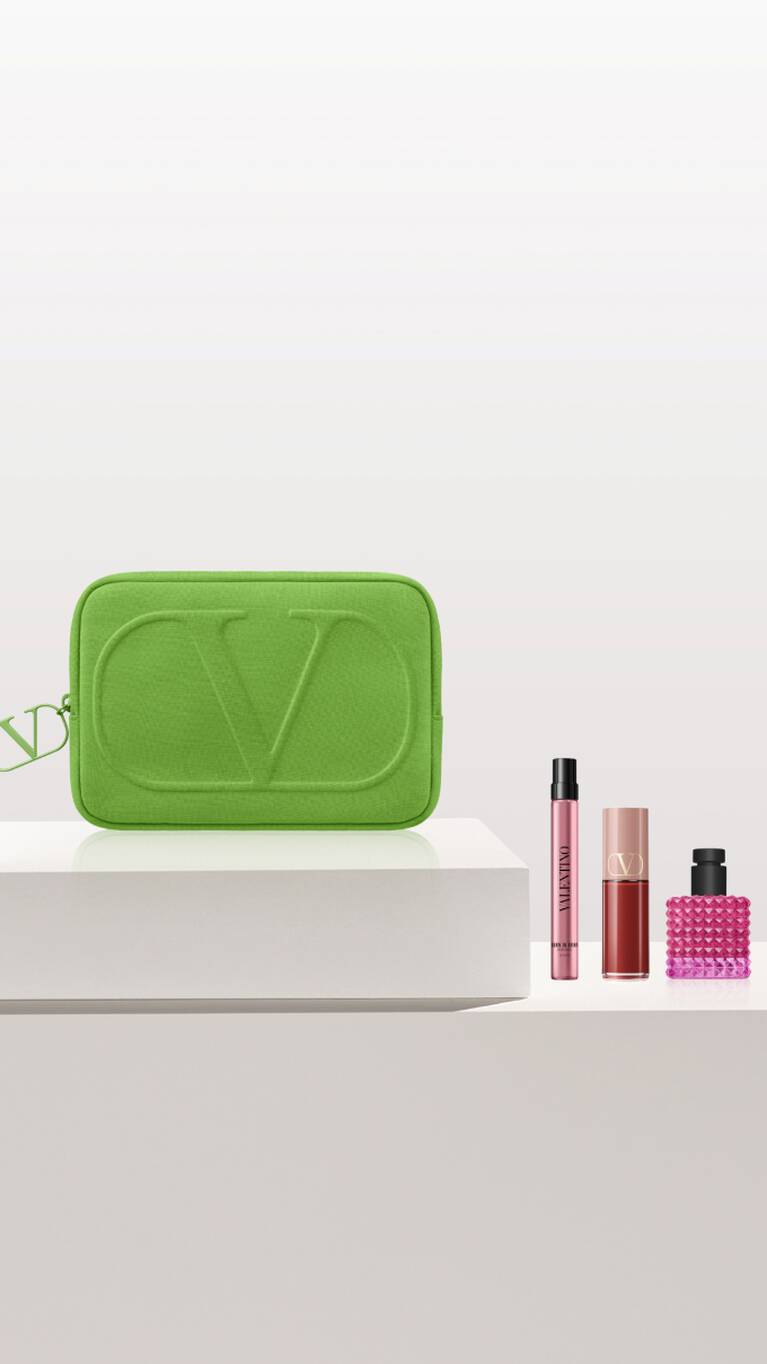 A vibrant green cosmetic pouch with a luxurious logo, accompanied by three elegant beauty products in stylish packaging.