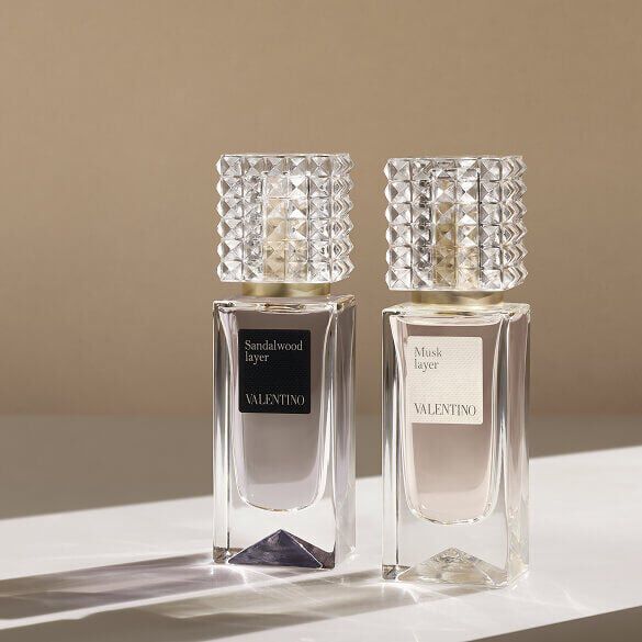 Two Valentino perfume bottles labeled Sandalwood Layer and Musk Layer displayed on a light surface