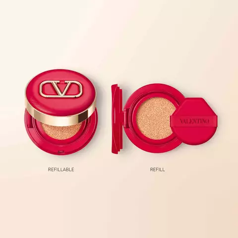 A red compacts makeup case with a gold logo labeled "REFILLABLE" next to an open refill with a red cap labeled "REFILL."
